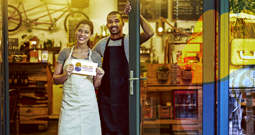 A photo of two business owners in the Ybor area showing off their Ybor business watch decal